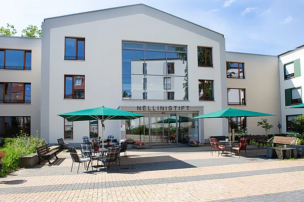 Vorplatz des Nellinistift mit Sonnenschirmen und Sitzgelegenheiten 